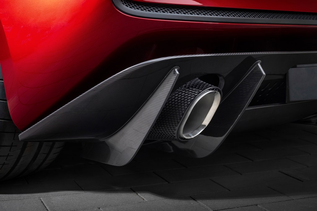 A detail of the exhaust and rear fender of a red McLaren McL 6GT. 