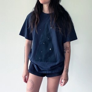 MQuan's The Space T is black with white stars, worn on a woman