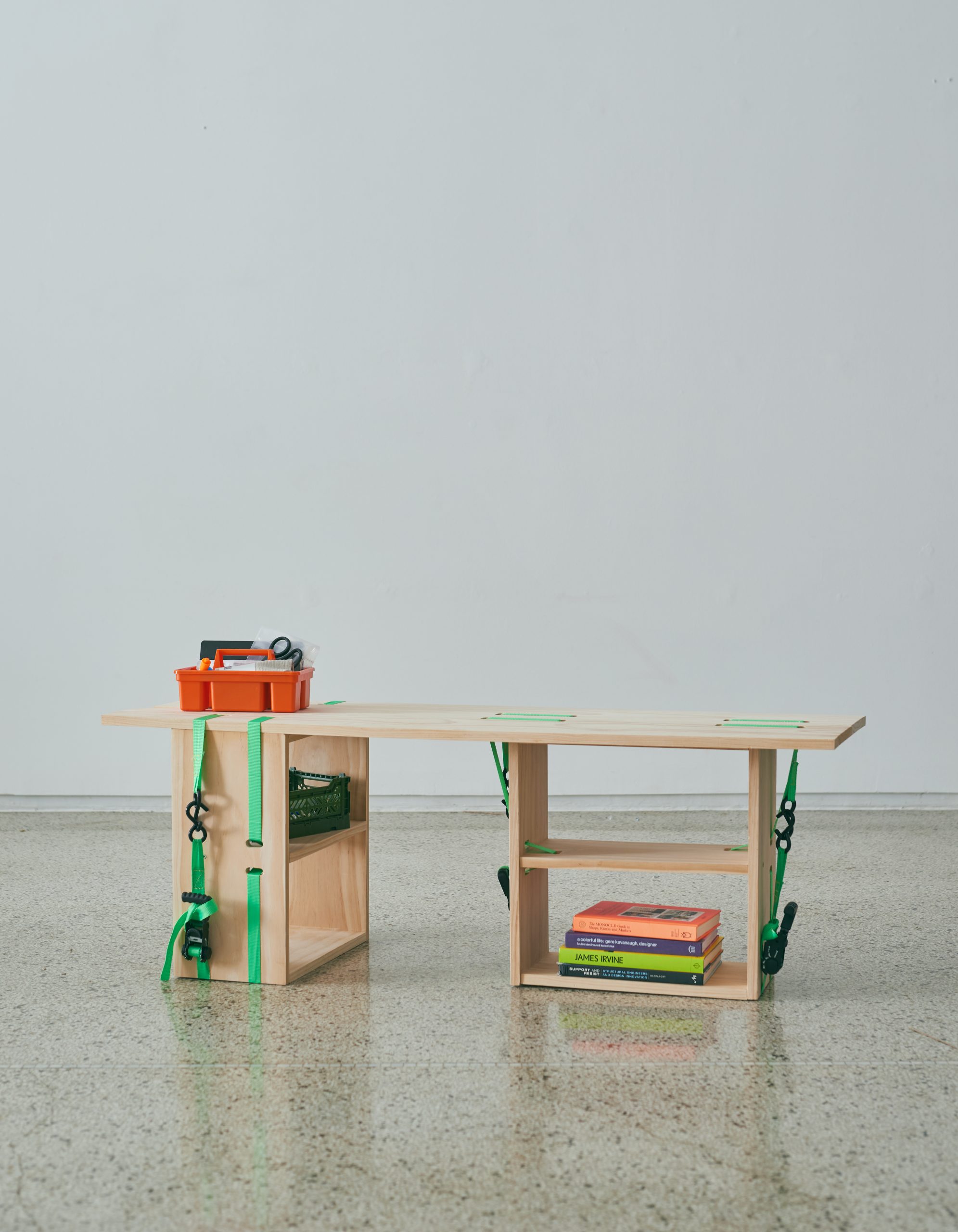 A light wood table with green straps holding it together.