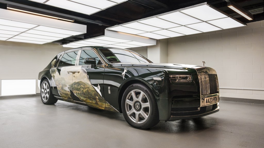 A black art car covered in artwork by KOZO, made to look like the paint is peeling to reveal an idyllic British landscape.