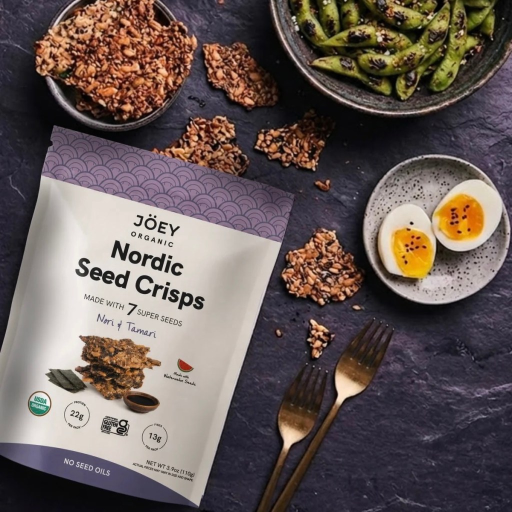 A package of Jöey Organics Nori + Tamari crisps on a background with food items