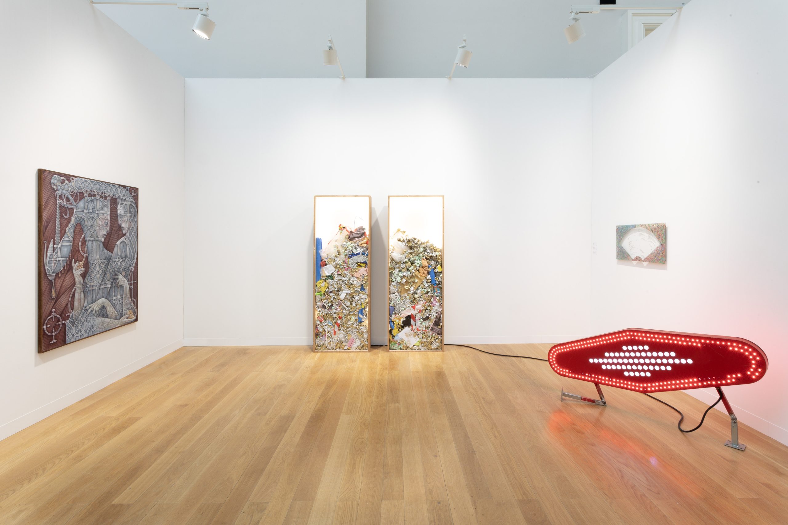 A gallery room with a large painting, three wall sculptures and a large, red illuminated sculpture sitting on the floor.