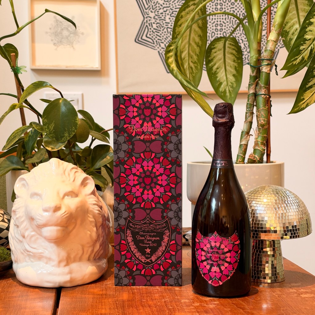 A box and bottle of Dom Pérignon's 2010 rosé Damien Herst edition on a table with other objects