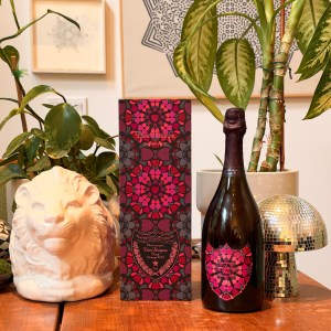 A box and bottle of Dom Pérignon's 2010 rosé Damien Herst edition on a table with other objects