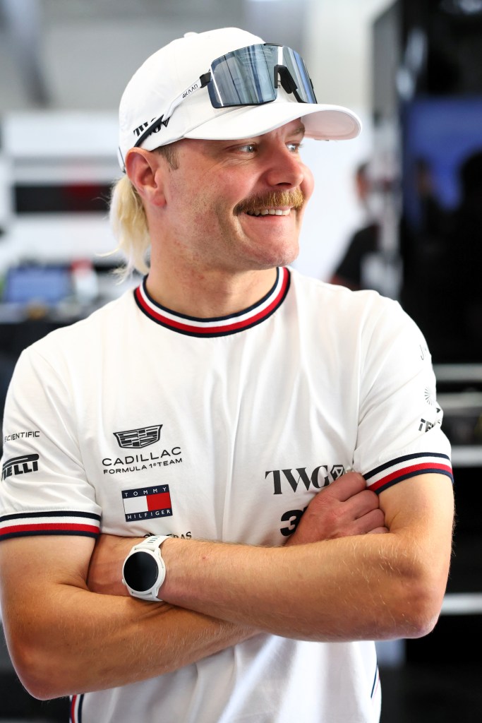 Valtteri Bottas with his arms crossed, looking to the right with a smile.