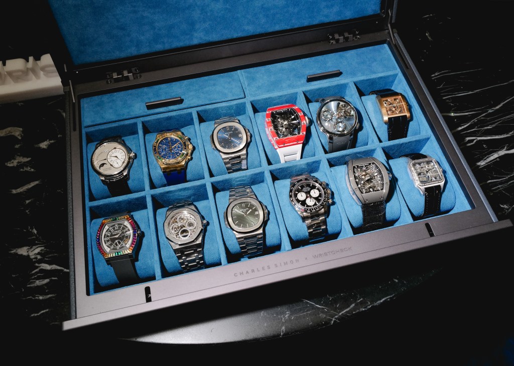A blue fabric-lined watch case with two rows of different luxury watches inside.