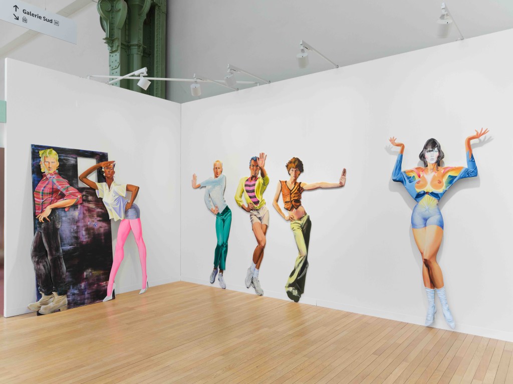 Lifesize figures wearing different outfits and different poses are arranged along two walls of a gallery space.